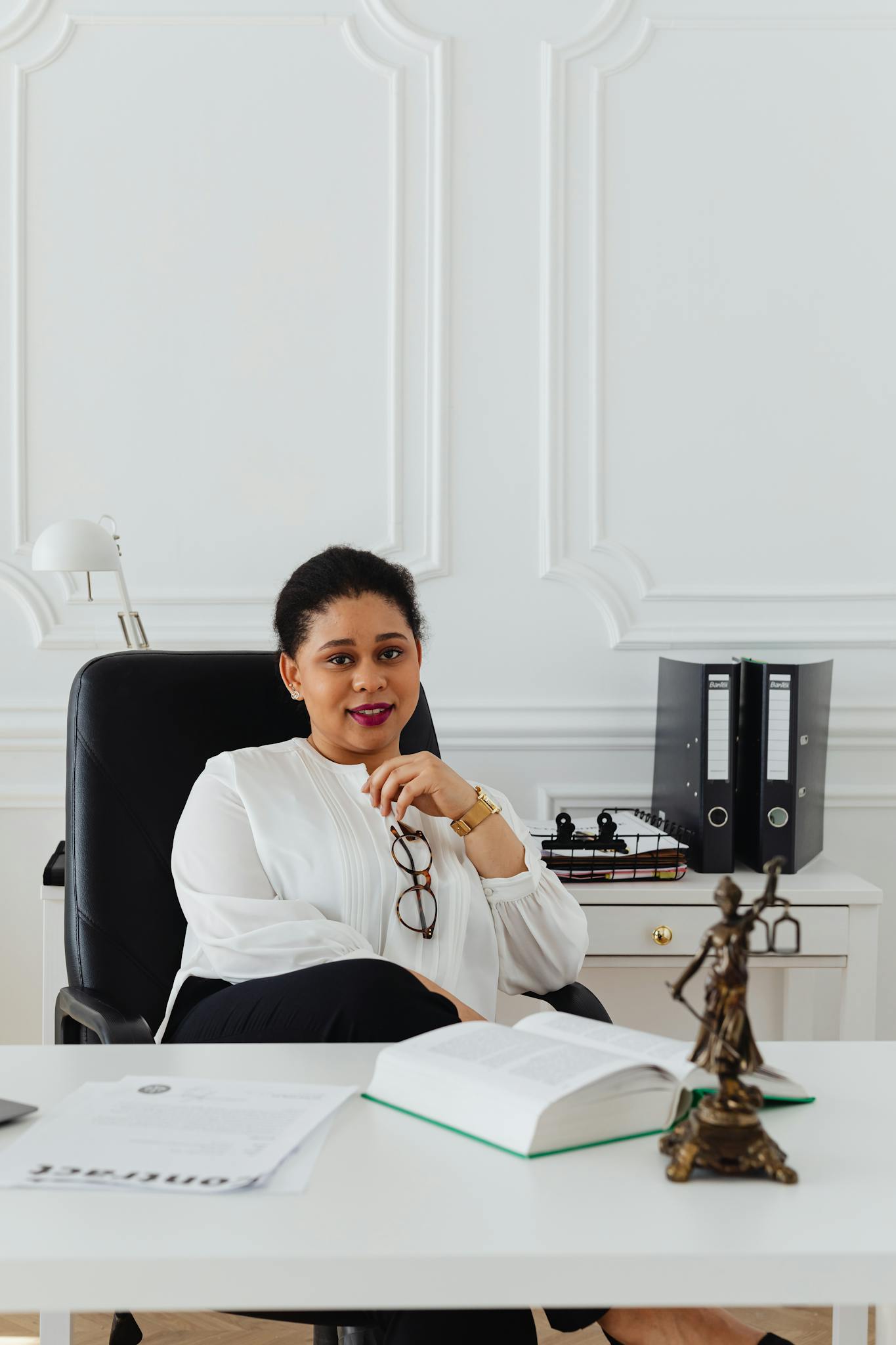 Woman in White Long Sleeve Shirt Sitting on Black Office Rolling Chair